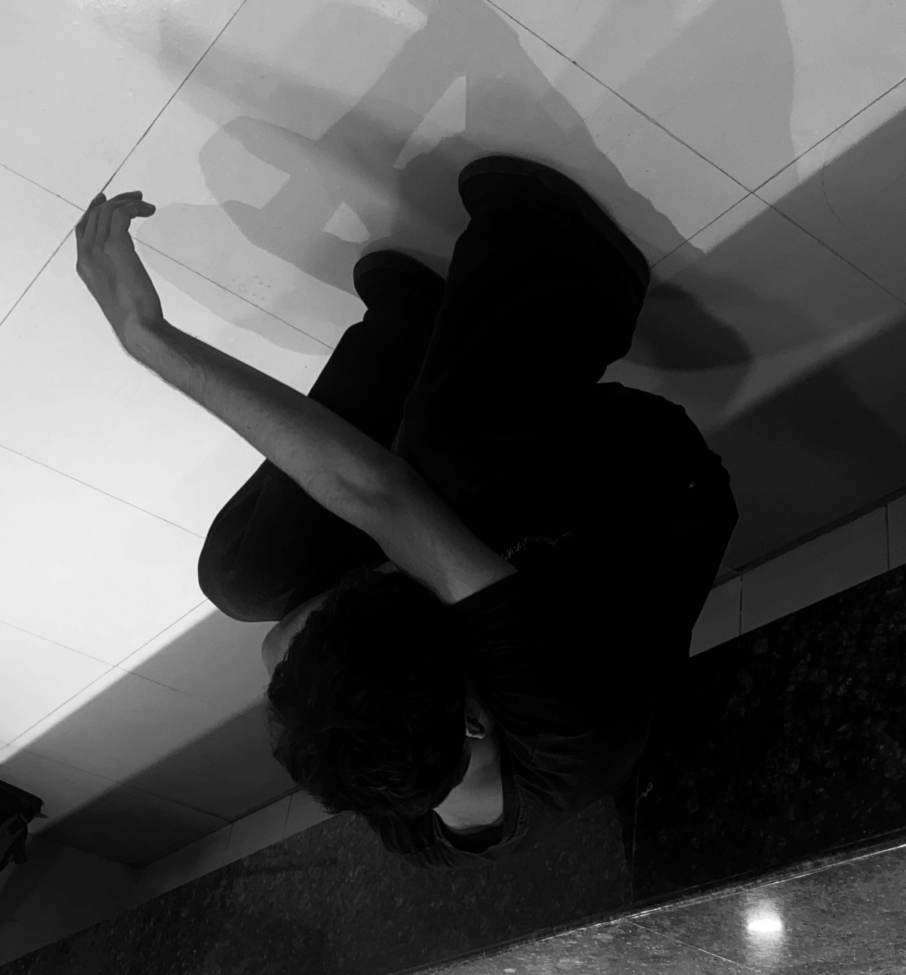 Person sitting on a ledge with a reflective surface below